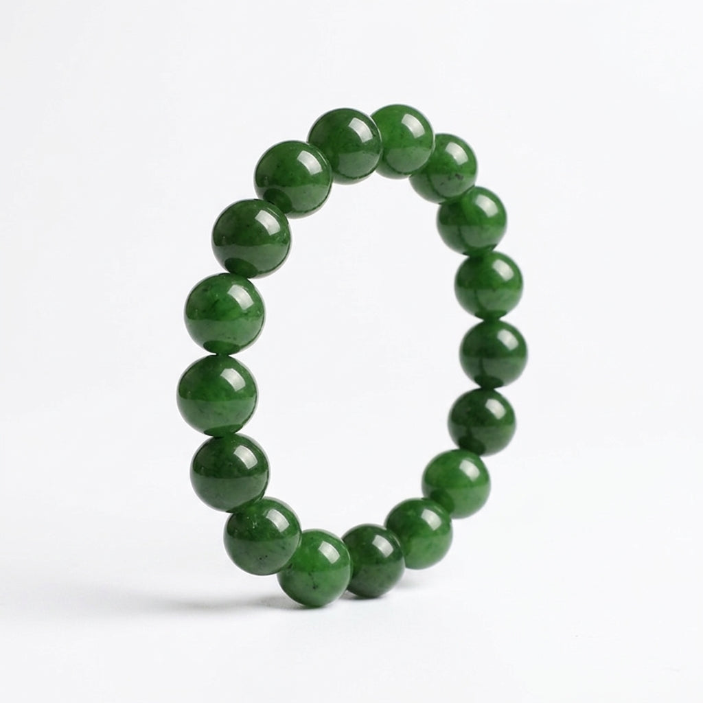 Bracelet circulaire en perles de jadéite naturelle sur fond blanc. Vue de profil montrant le polissage miroir.