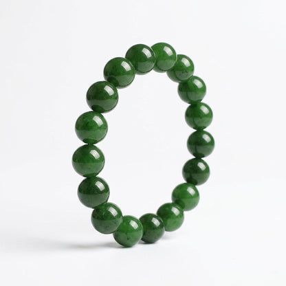 Bracelet circulaire en perles de jadéite naturelle sur fond blanc. Vue de profil montrant le polissage miroir.